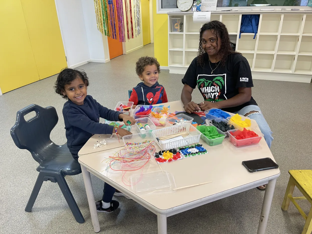 Children and an educator enjoying a hands-on craft activity